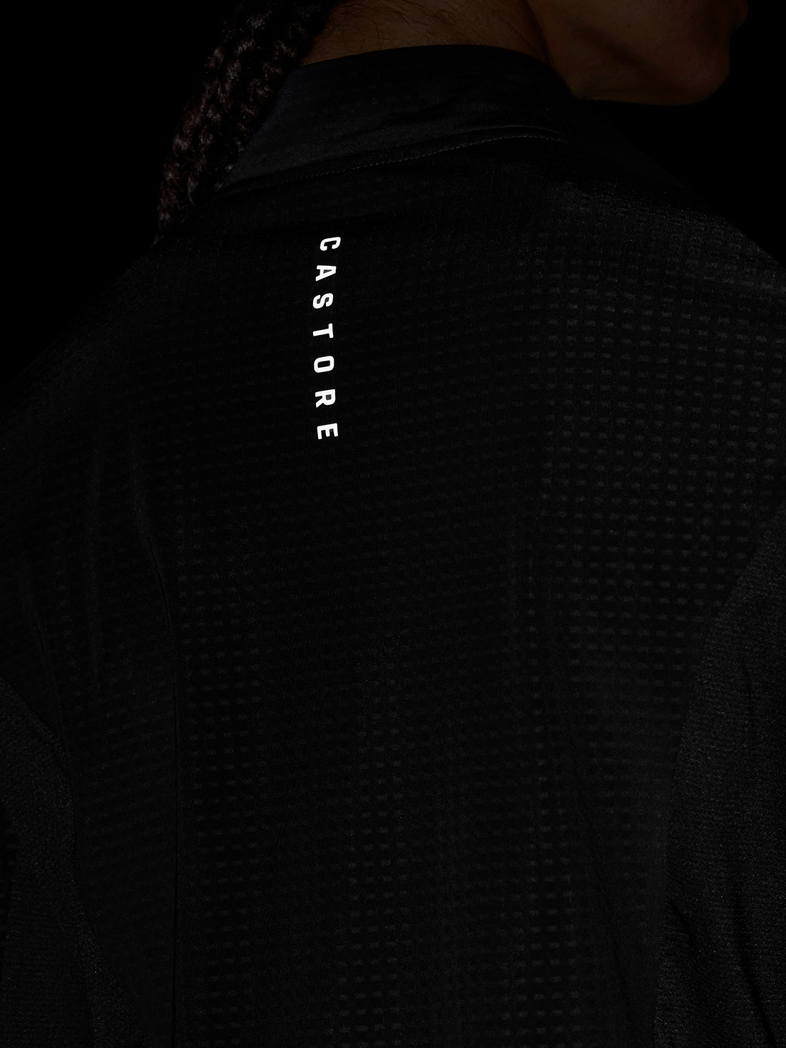 Back view of black Apex Training top highlighting vertical Castore branding on the left sleeve.