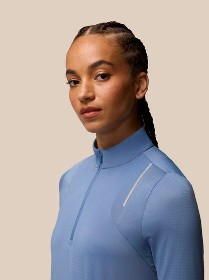 Portrait of a model in a light blue Apex Training quarter zip top with funnel collar.