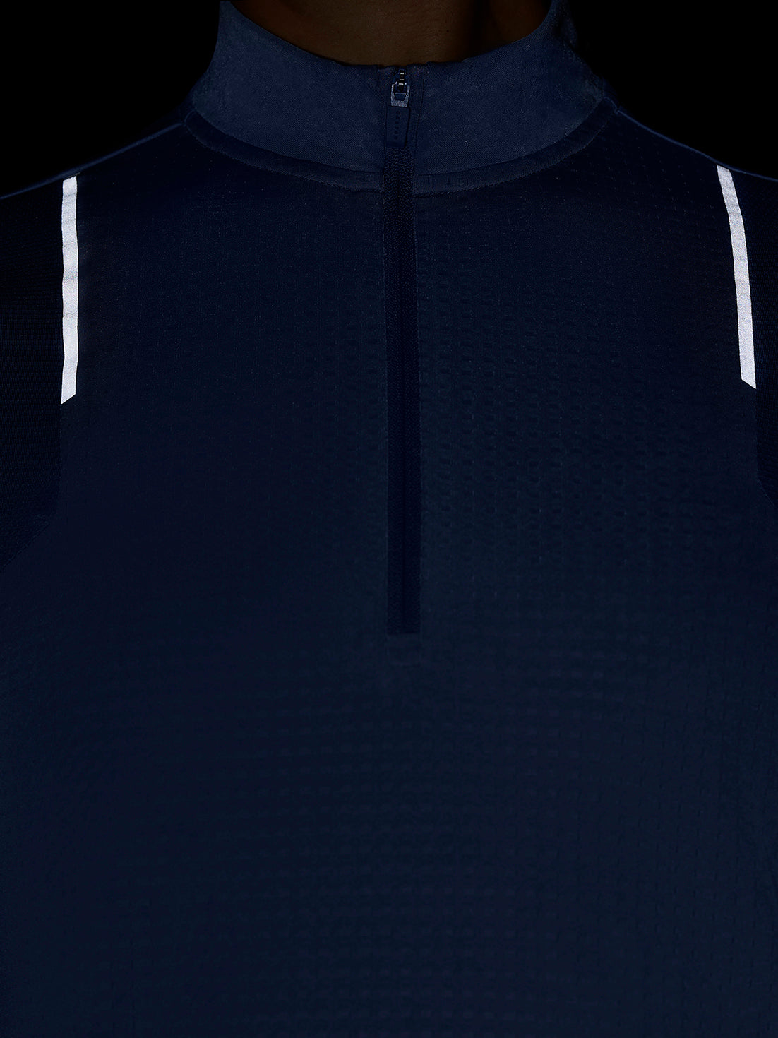 Close up of the front of a dark blue Apex Training quarter zip top with center zipper and funnel collar