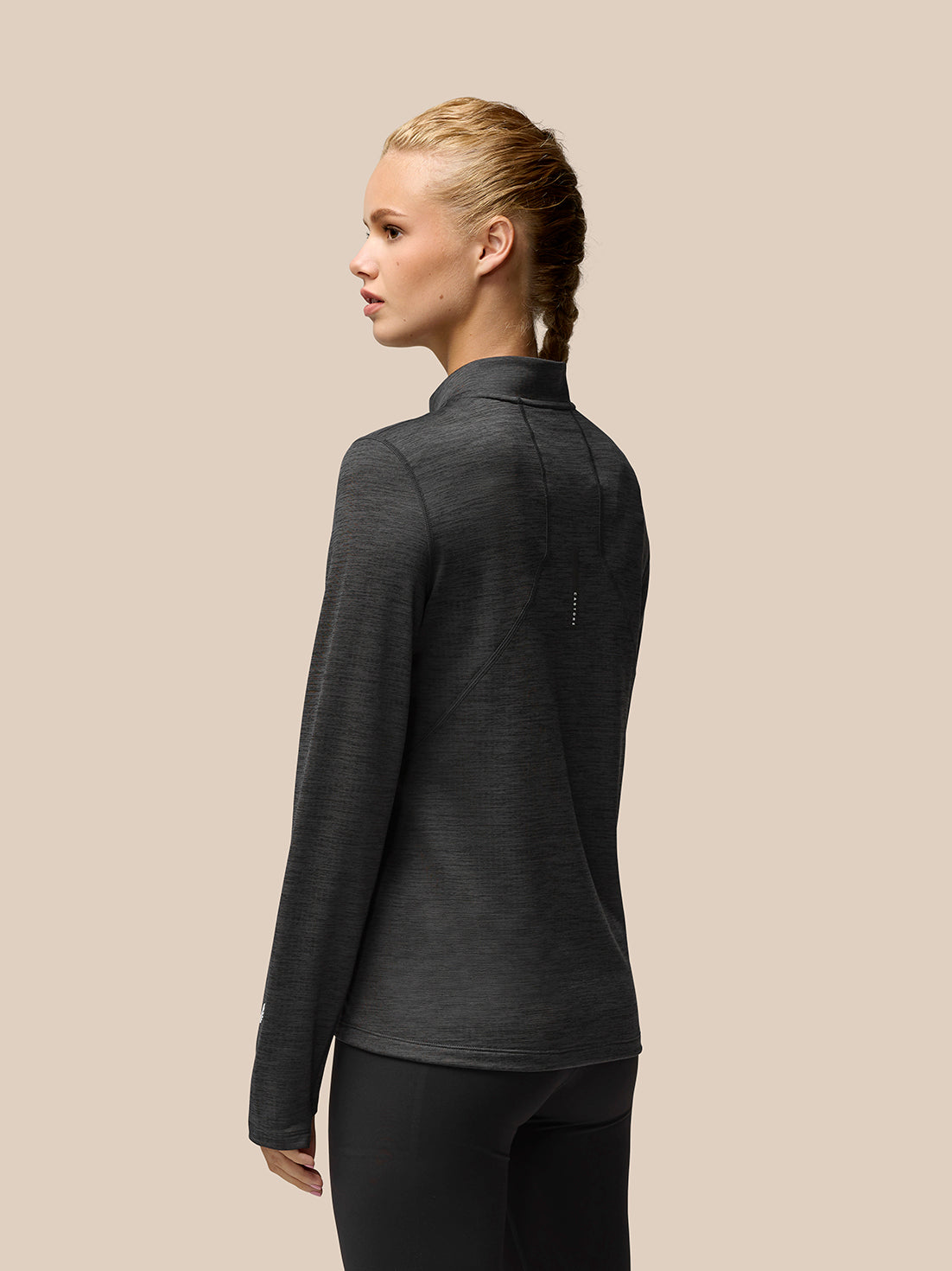 Back view of Flow Training fleece half zip top in dark charcoal highlighting back seam and dropped hem