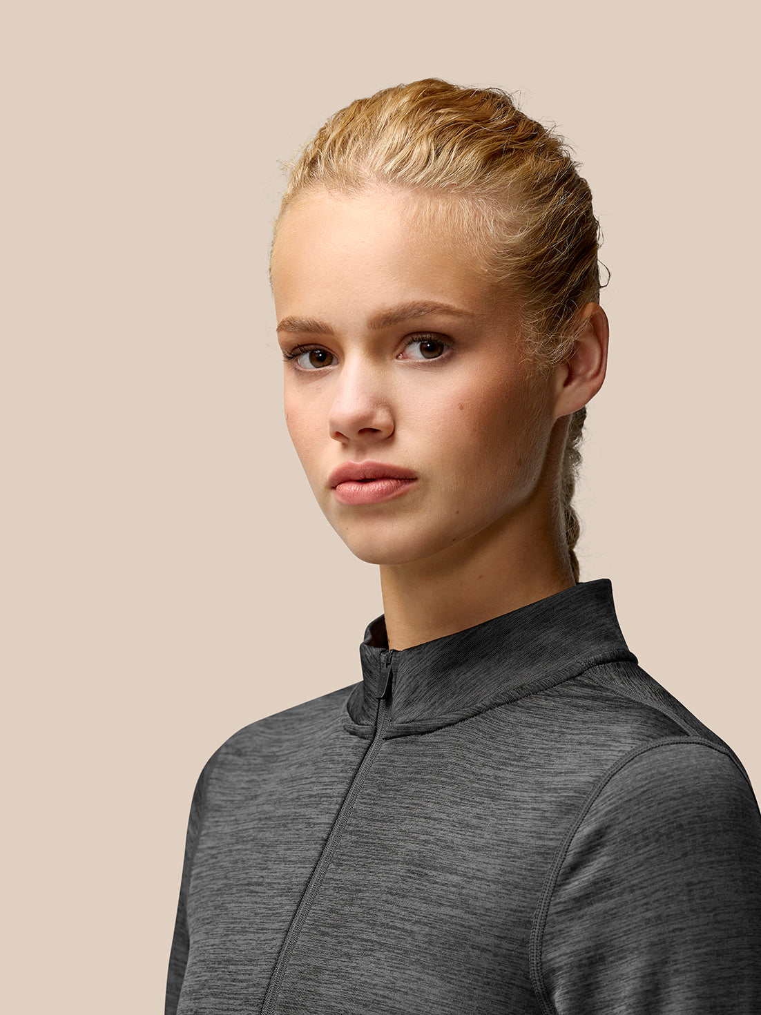 Portrait of a model wearing Flow Training fleece half zip top in dark charcoal gray.