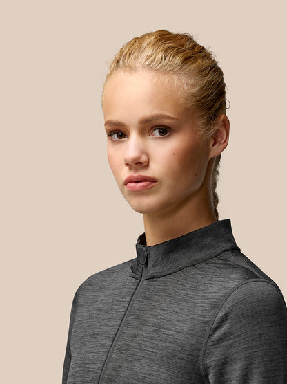 Portrait of a model wearing Flow Training fleece half zip top in dark charcoal gray.