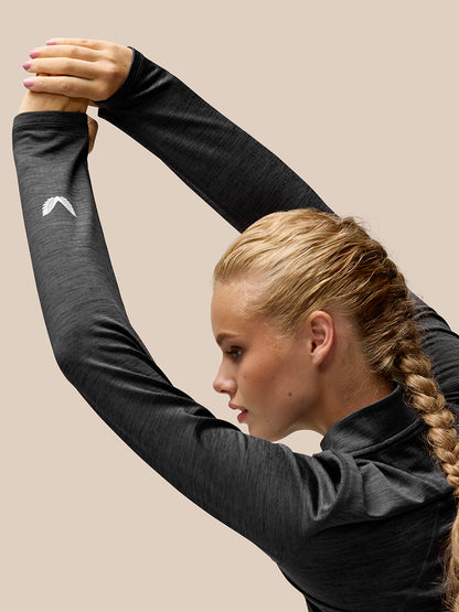Side view of a woman in Flow Training fleece half zip top with AerTek branding on the back and Castore logo on the sleeve.