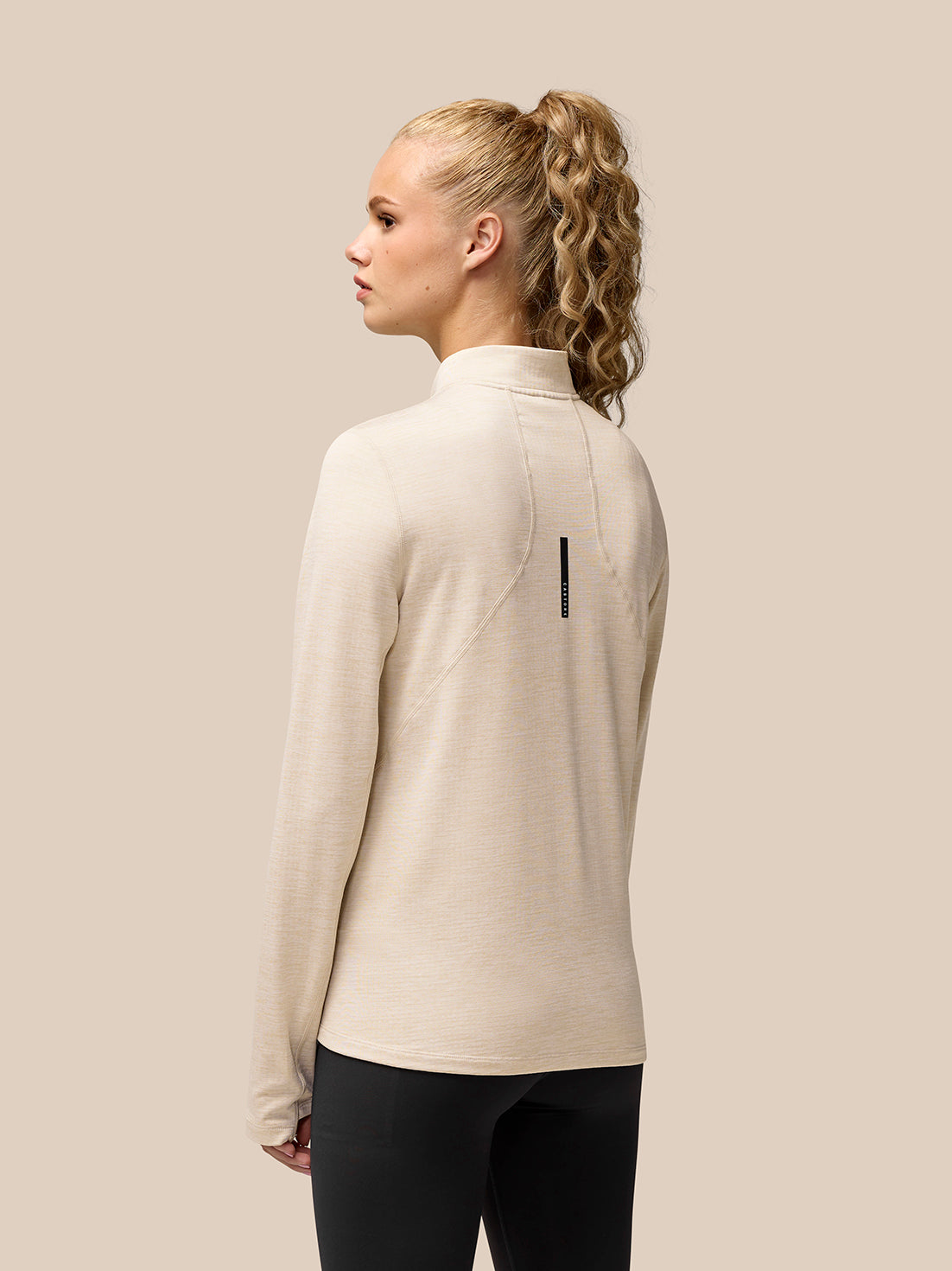Back view of beige Flow Training half zip fleece showing branding on the upper back