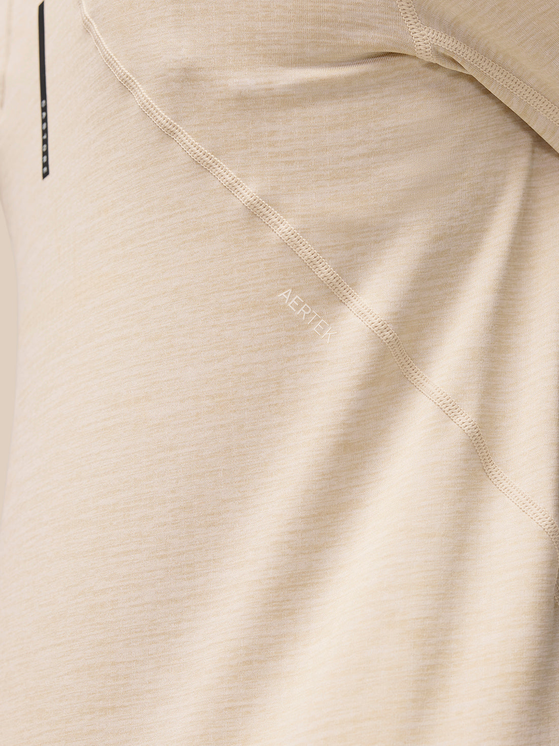 Close-up of beige Flow Training fabric showing AerTek branding along the seam.