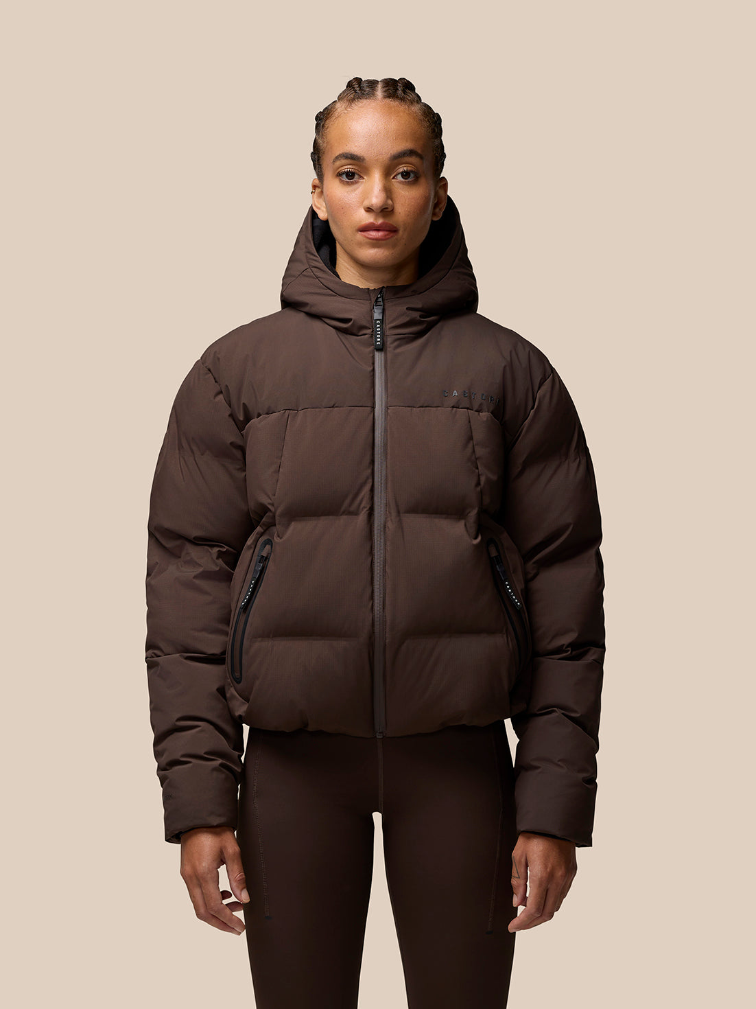 Brown Quilts Lifestyle Jacket worn by a model front view with hood in a puffer silhouette