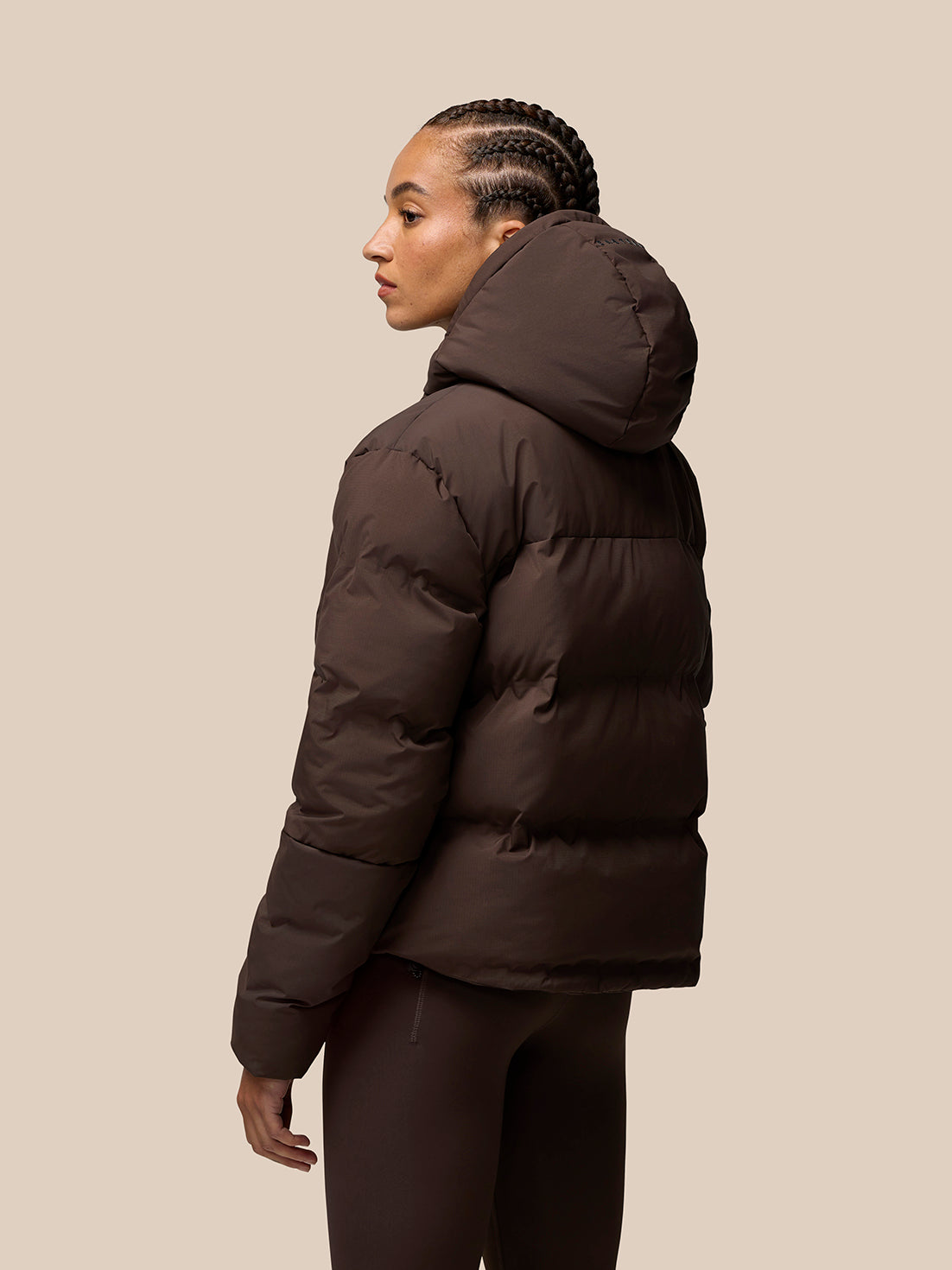 Brown Quilts Lifestyle Jacket shown from back on a model with a hooded puffer design