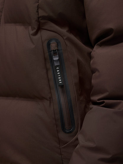 Close-up of the brown Quilts Lifestyle Jacket pocket with vertical zipper and Castore branding.