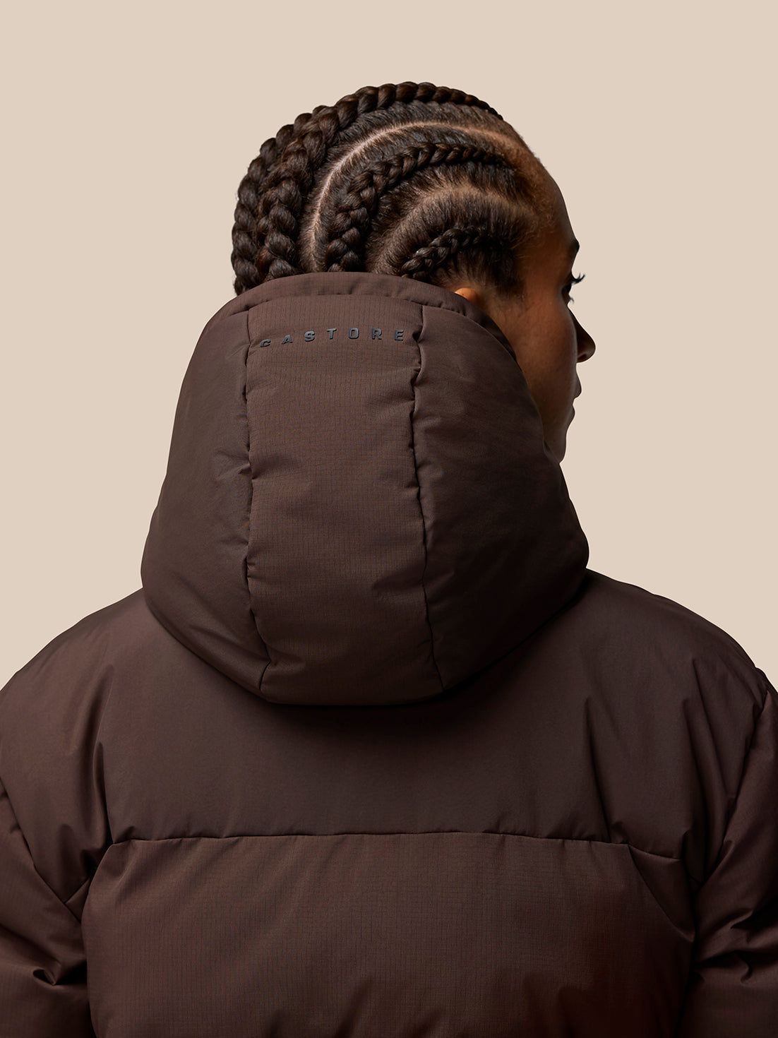 Back view of brown Quilts Lifestyle Jacket with insulated hood and Castore branding on the hood