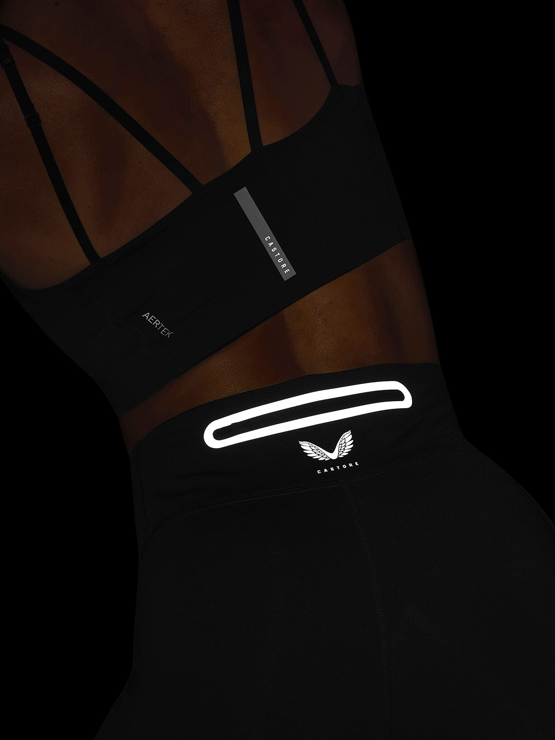 Close-up of the black Apex leggings waistband with reflective loop detail and Castore logo.