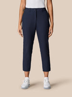 Front view of a model wearing midnight navy Golf Club Trousers 7/8 length with belt loops and side pockets.