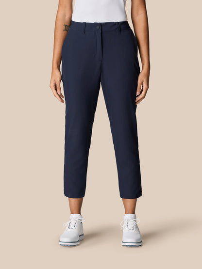 Front view of a model wearing midnight navy Golf Club Trousers 7/8 length with belt loops and side pockets.