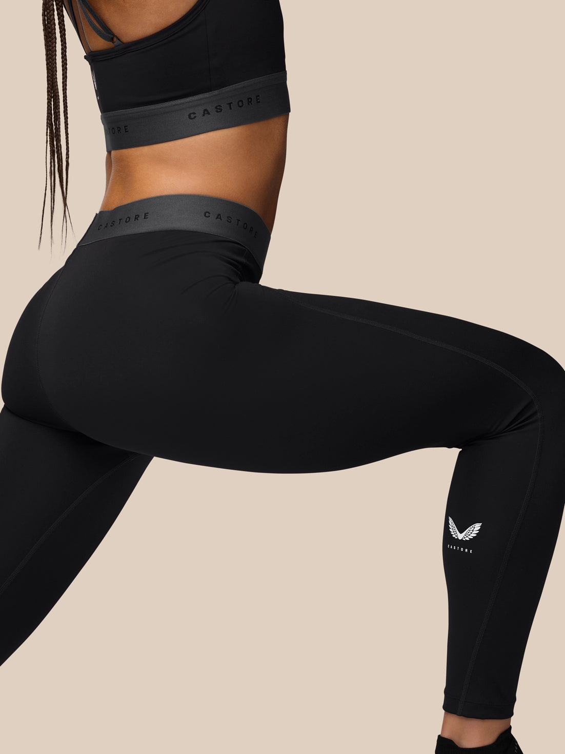 Back view of a model in black Adapt Training Leggings with a grey waistband highlighting a secure fit.