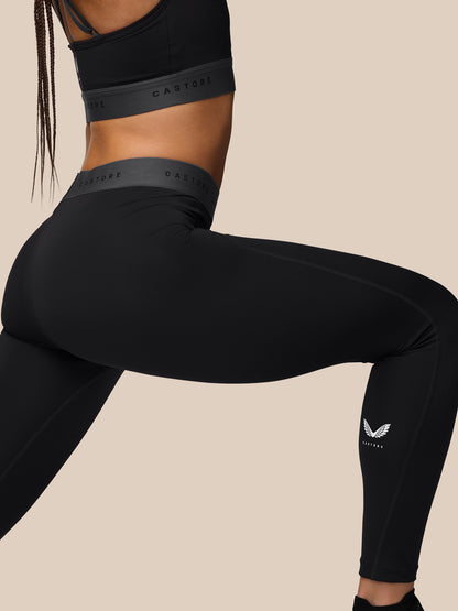 Back view of a model in black Adapt Training Leggings with a grey waistband highlighting a secure fit.