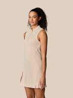 Female model in Pinnacle Dress Stone sleeveless with a quarter zip and streamlined silhouette
