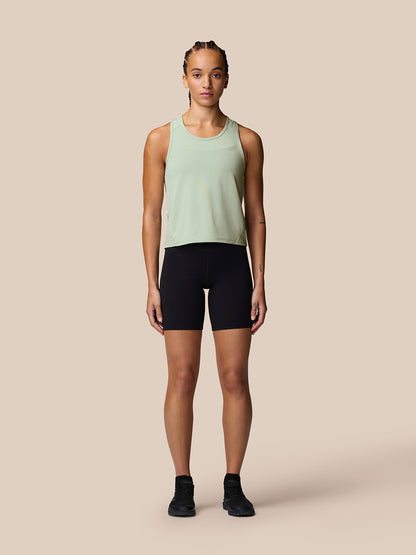 Model wearing Apex Training Tank Top in sage green with racerback and black shorts.