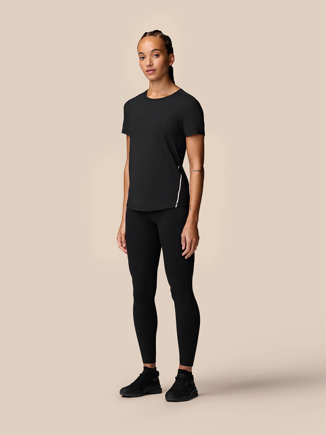 Full-body front view of a model in black Apex Training T-Shirt with reflective side stripe.
