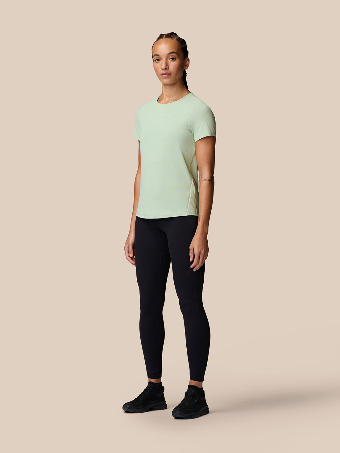 Woman wearing Sage Apex Training T-Shirt with black leggings and sneakers
