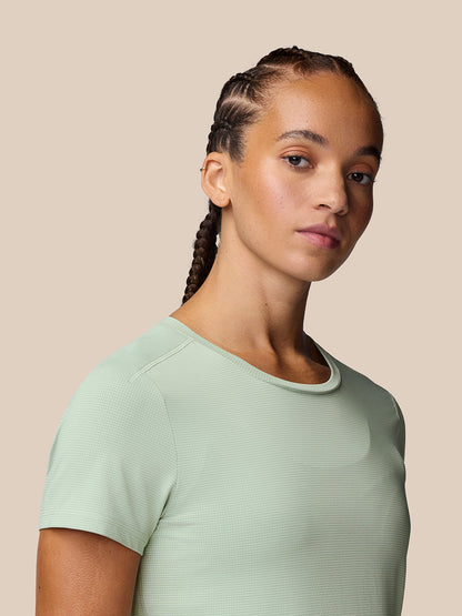 Side profile of model wearing Sage Apex Training T-Shirt in soft sage color