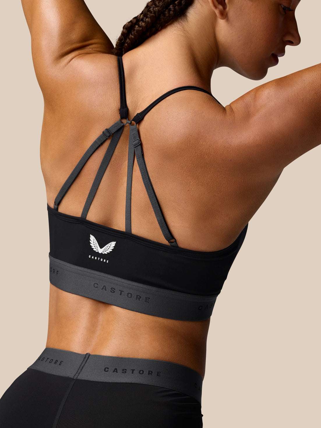 Back view of the black Adapt Training Sports Bra with slender cross straps and Castore logo band along the bottom.