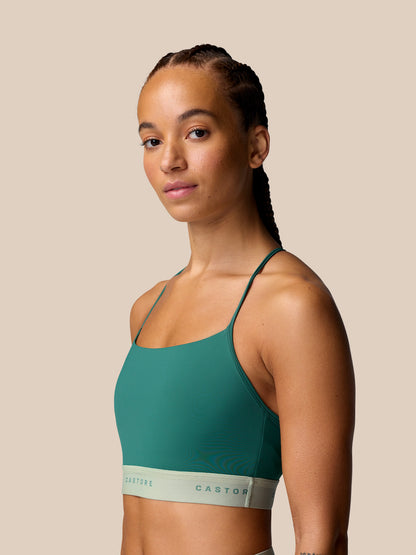 Model wearing Adapt Training Sports Bra in seafoam teal with slender straps, front view.