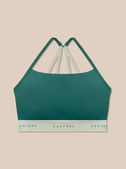 Seafoam Adapt Training Sports Bra with beige back straps against a peach background.