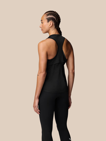 Back view of a woman in a black Adapt Training Tank Top with a racerback and dropped hem