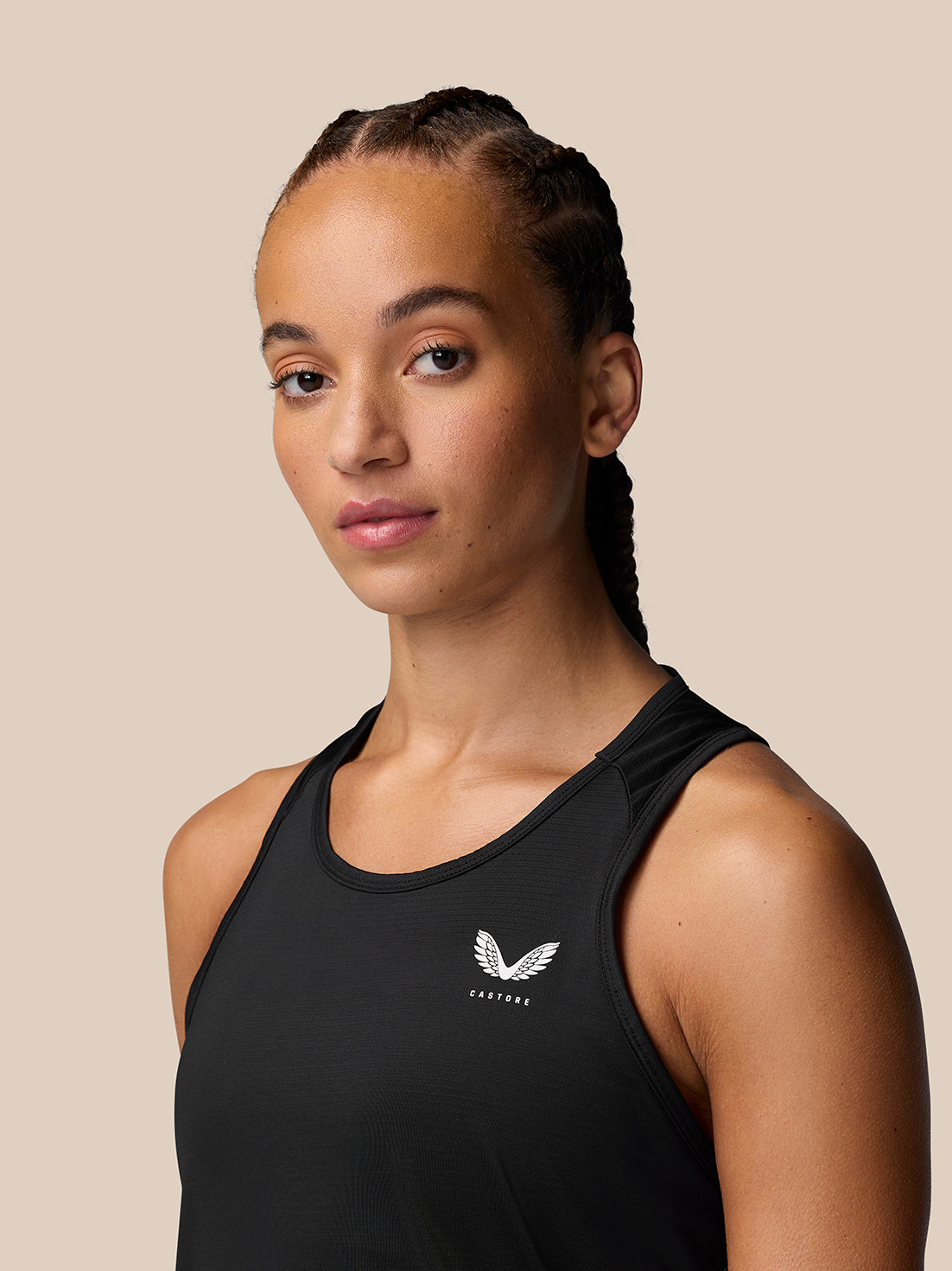 Front view of a woman wearing a black Adapt Training Tank Top with a crew neck and small white logo on the chest