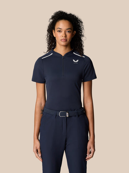 Female model wearing midnight navy Pinnacle Polo with white piping and zip front.