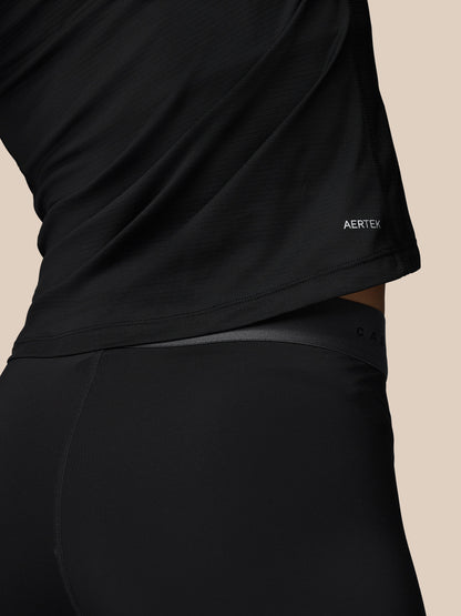 Close up of the lower back area showing the hem of the black Adapt Training top with AERTEK label.