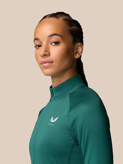 Three-quarter view of a woman wearing seafoam Adapt Training 1/2 Zip Top with stand collar and chest logo