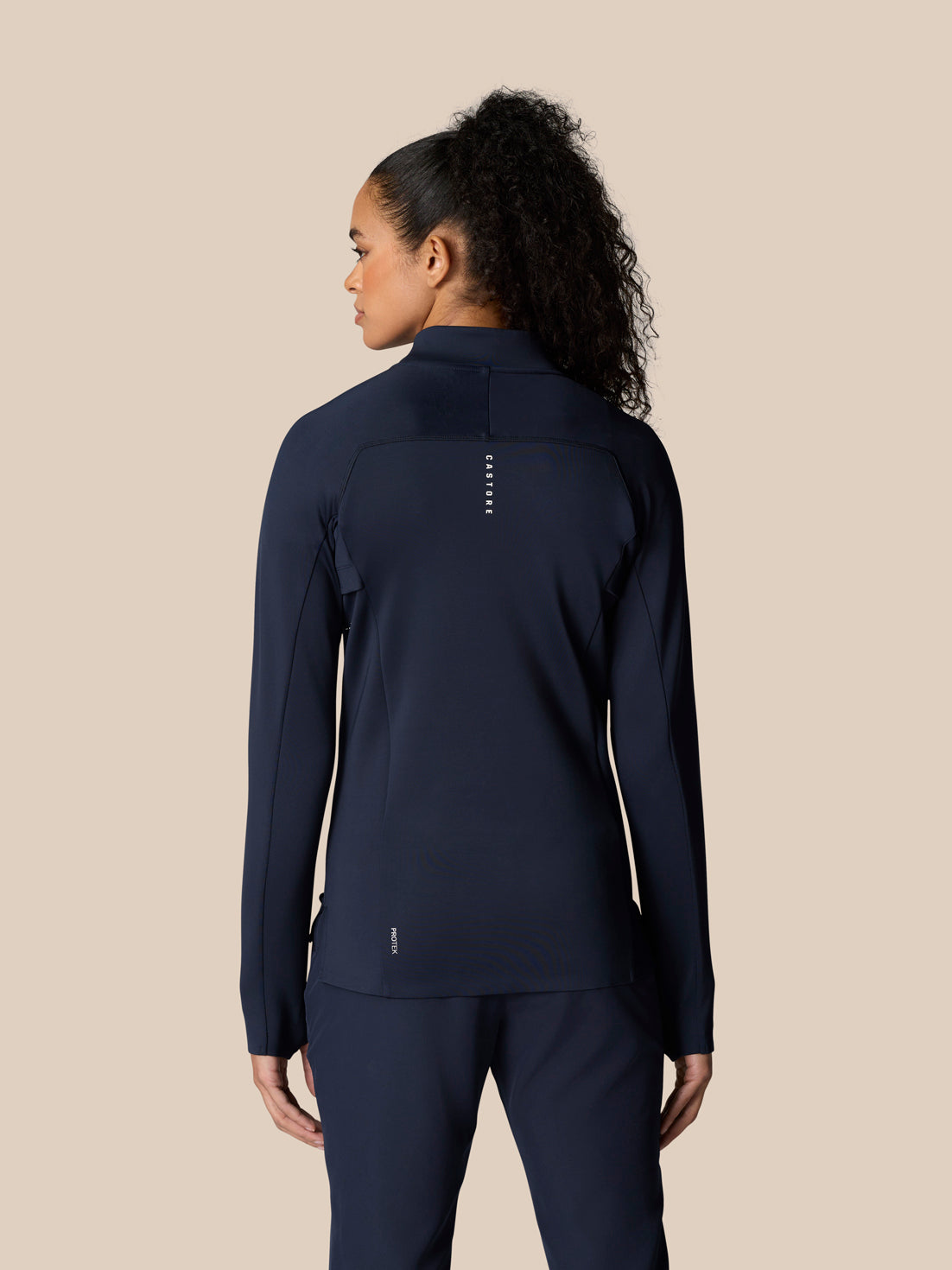 Back view of a model in Midnight Navy Pinnacle LVS ½ Zip Top showing back panels and logo details.