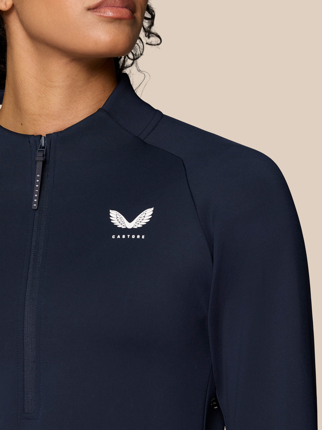 Front close up of navy Pinnacle LVS half zip top with chest logo and zipper detail
