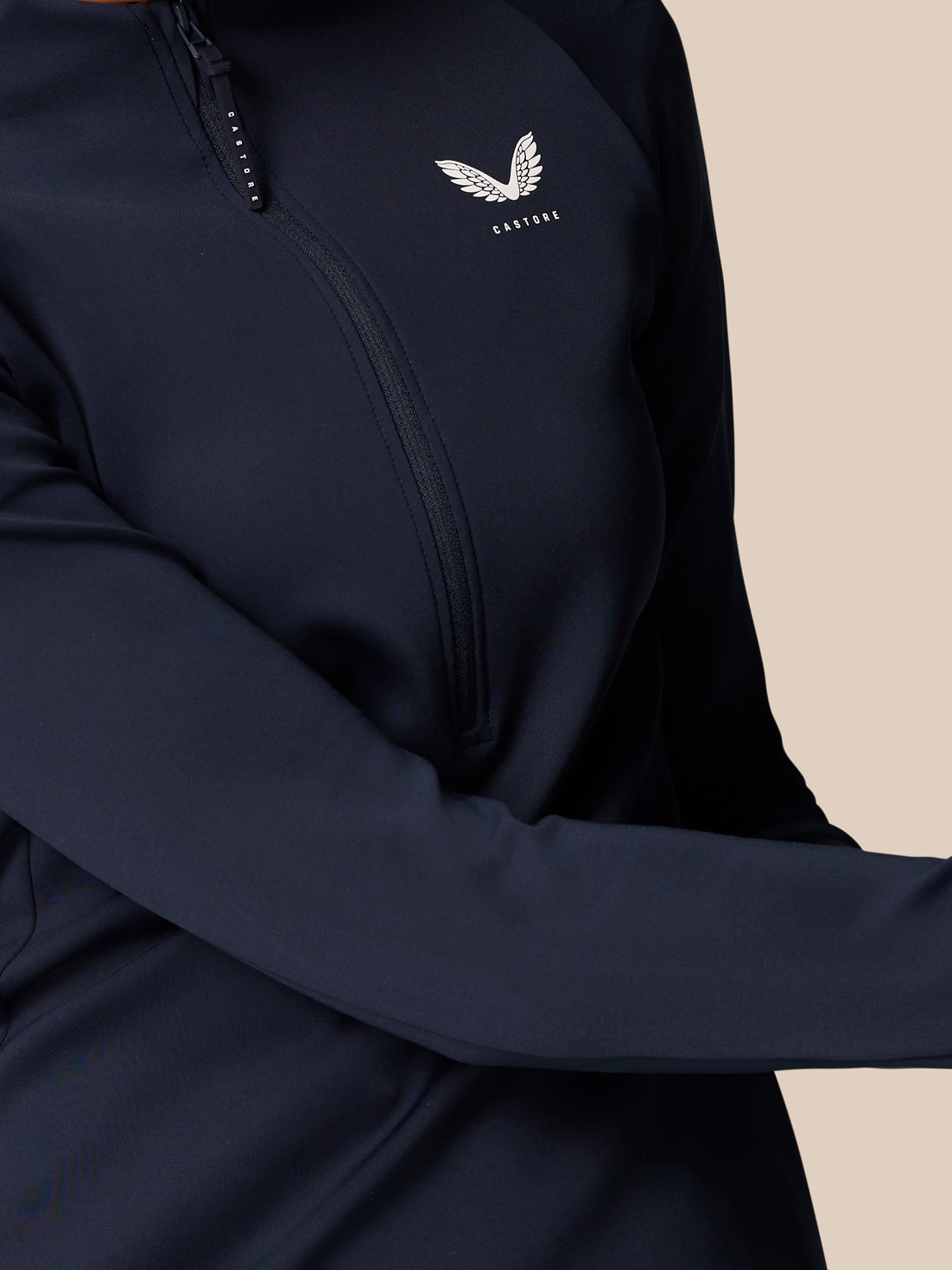 Close up of navy Pinnacle LVS half zip top showing front zipper and Castore wing logo