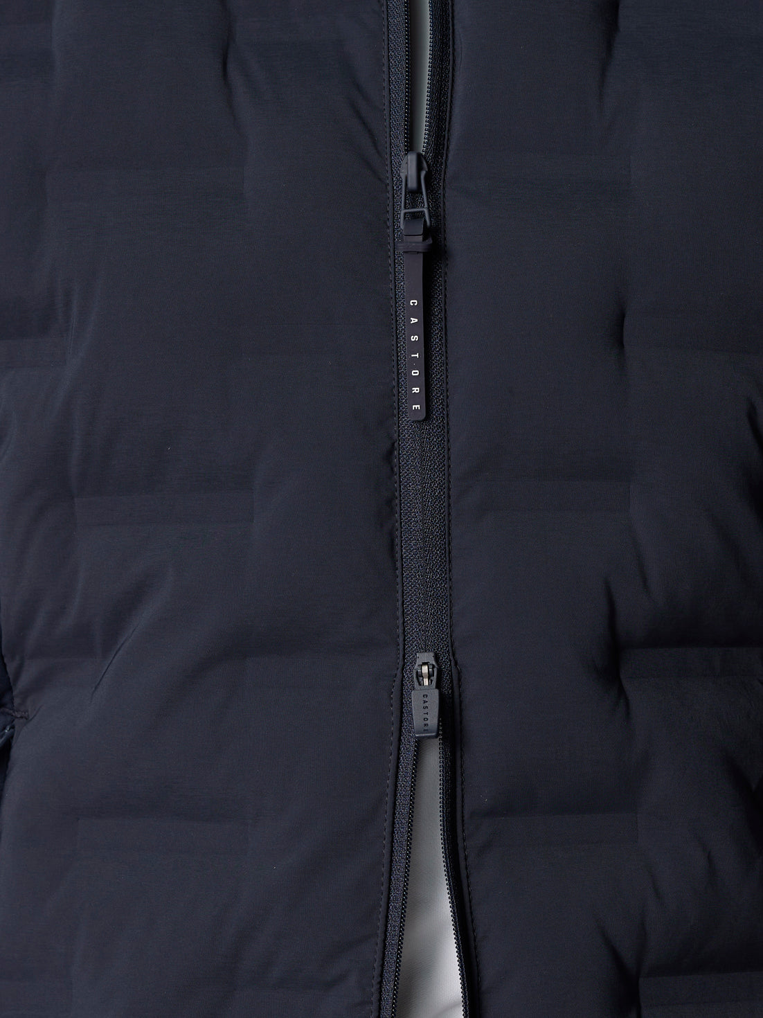 Close-up of navy front zipper on Pinnacle Hybrid Gilet with Castore pull
