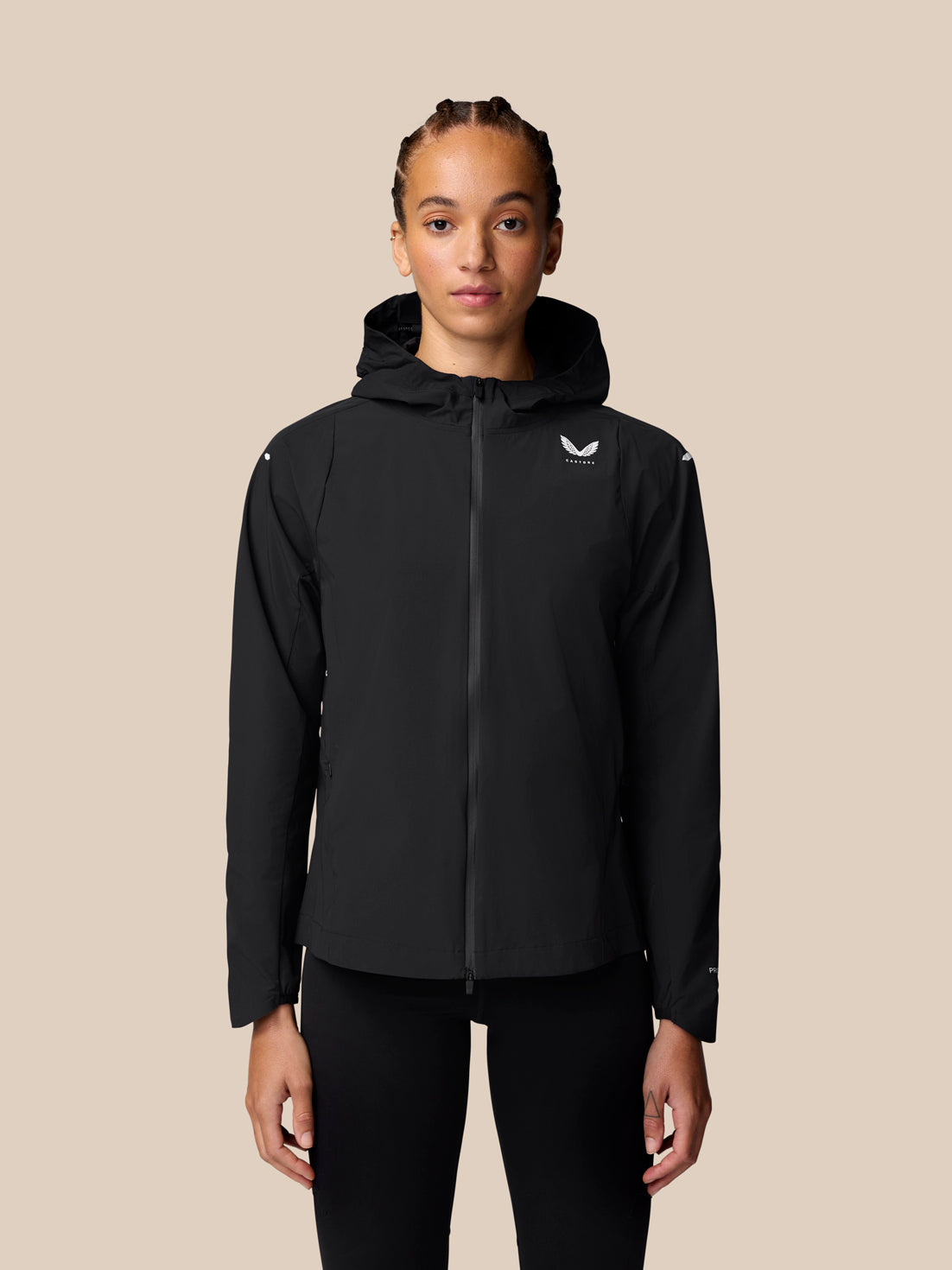 Front view of a woman wearing a black Apex Training Wind Jacket with hood and full front zipper