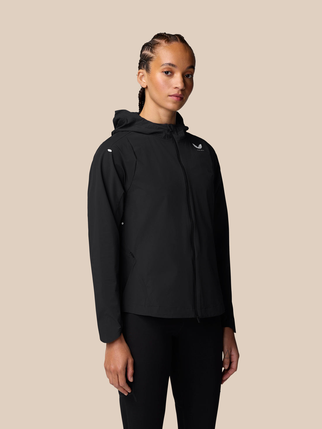 Front view of a woman wearing the Apex Training Wind Jacket in black with hood