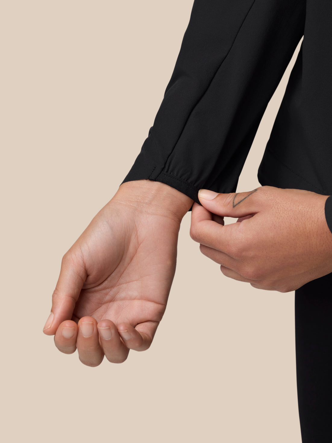 Sleeve cuff detail with PROTEK branding on the black wind jacket.
