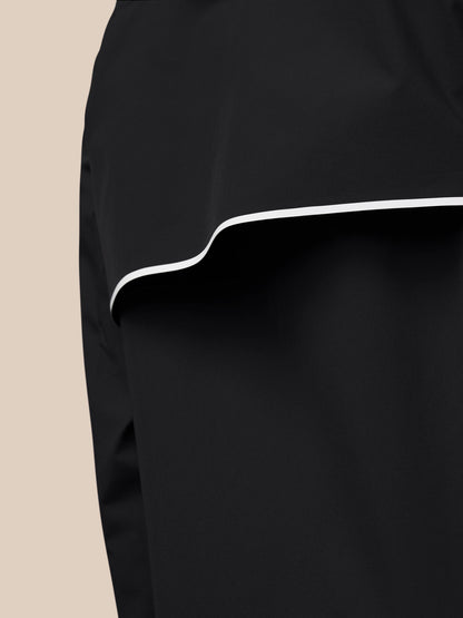 Close-up of the black wind jacket hem with white piping detail