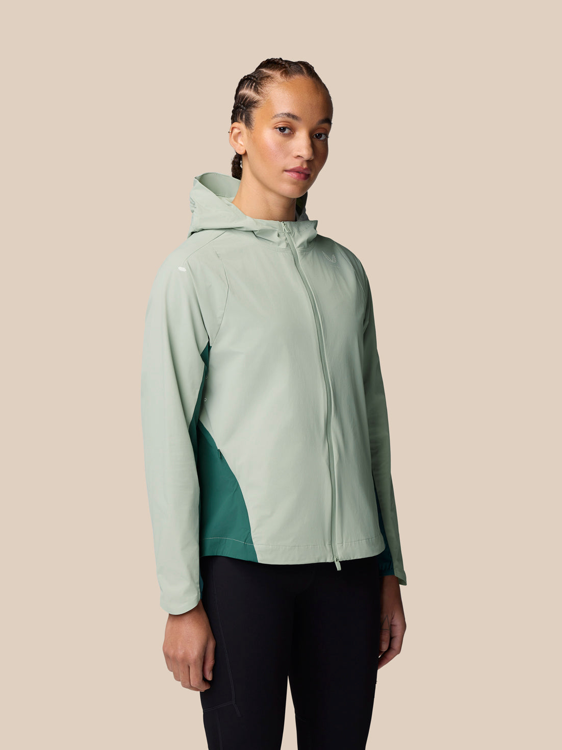 Model wearing Sage Apex Training Wind Jacket with hood against a beige background.
