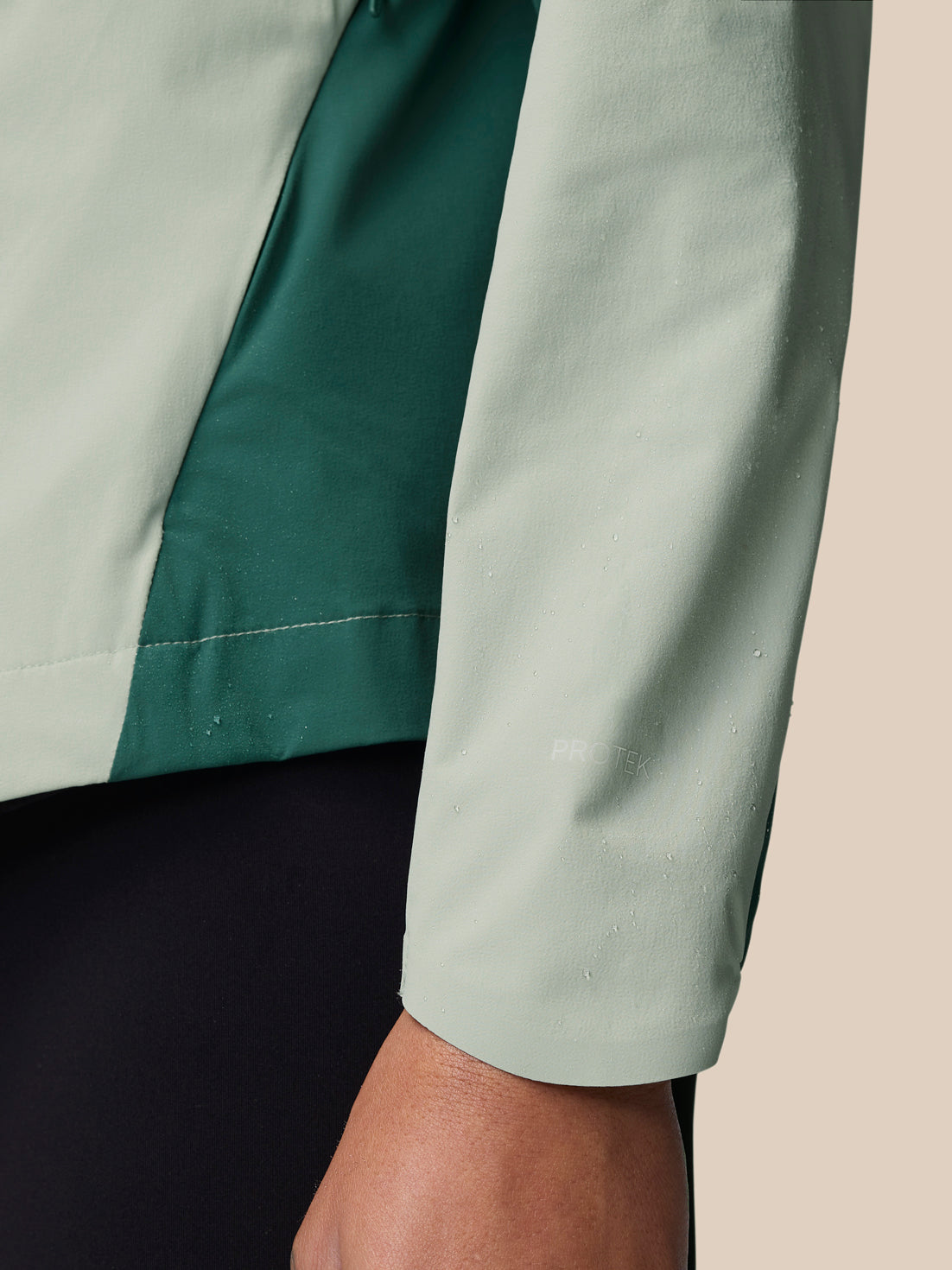Close-up of Sage wind jacket sleeve with two-tone panels and ProTek marking.