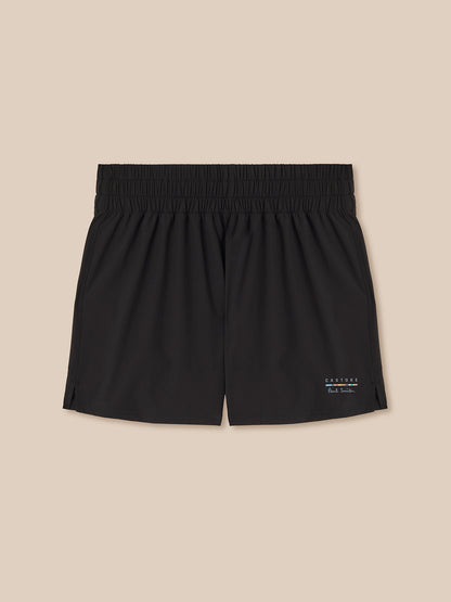 Black shorts with a brand logo on a beige background