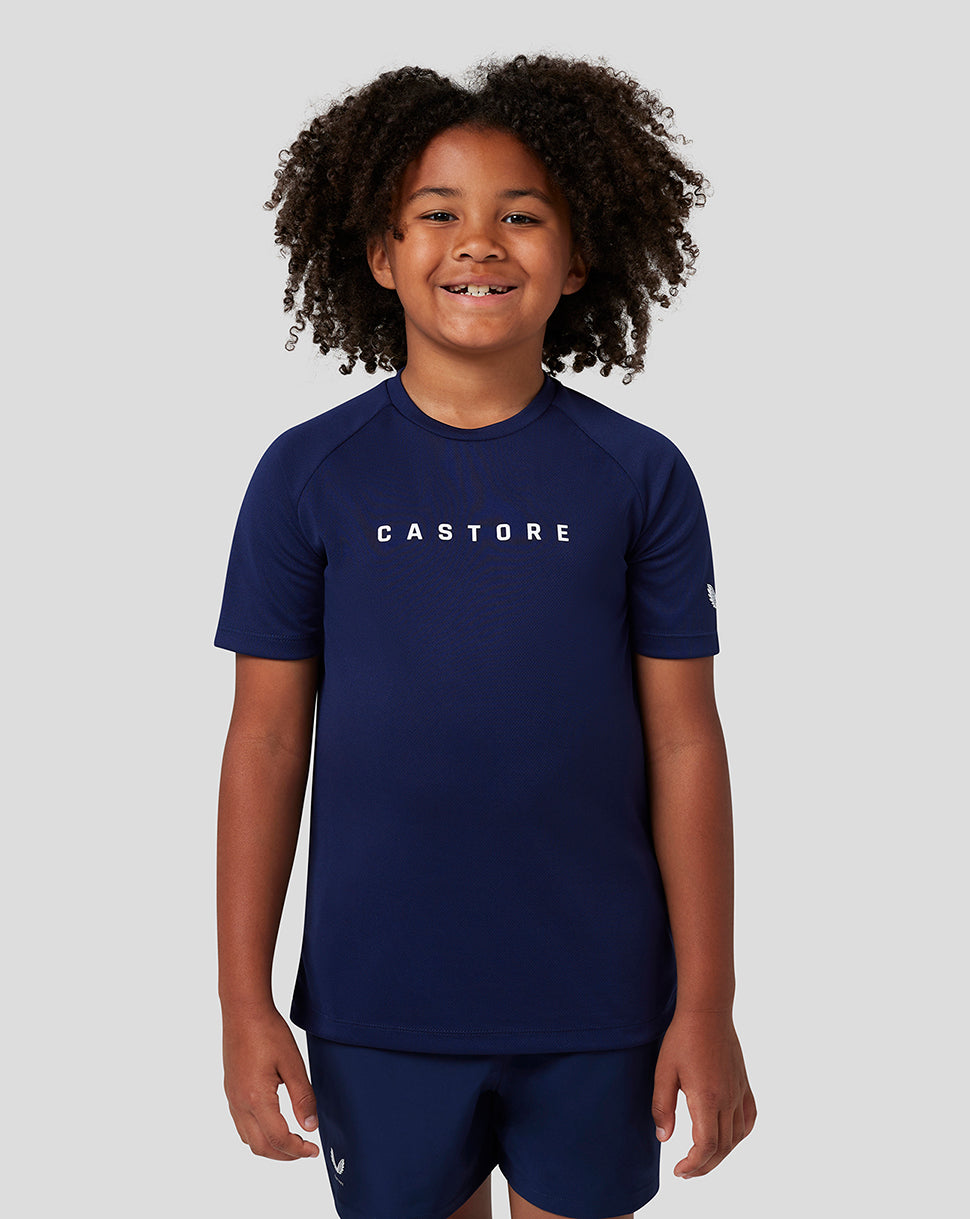 Young child in navy Castore short sleeve raglan T shirt with logo on the chest