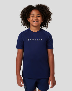 Young child in navy Castore short sleeve raglan T shirt with logo on the chest