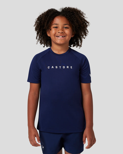 Young child in navy Castore short sleeve raglan T shirt with logo on the chest