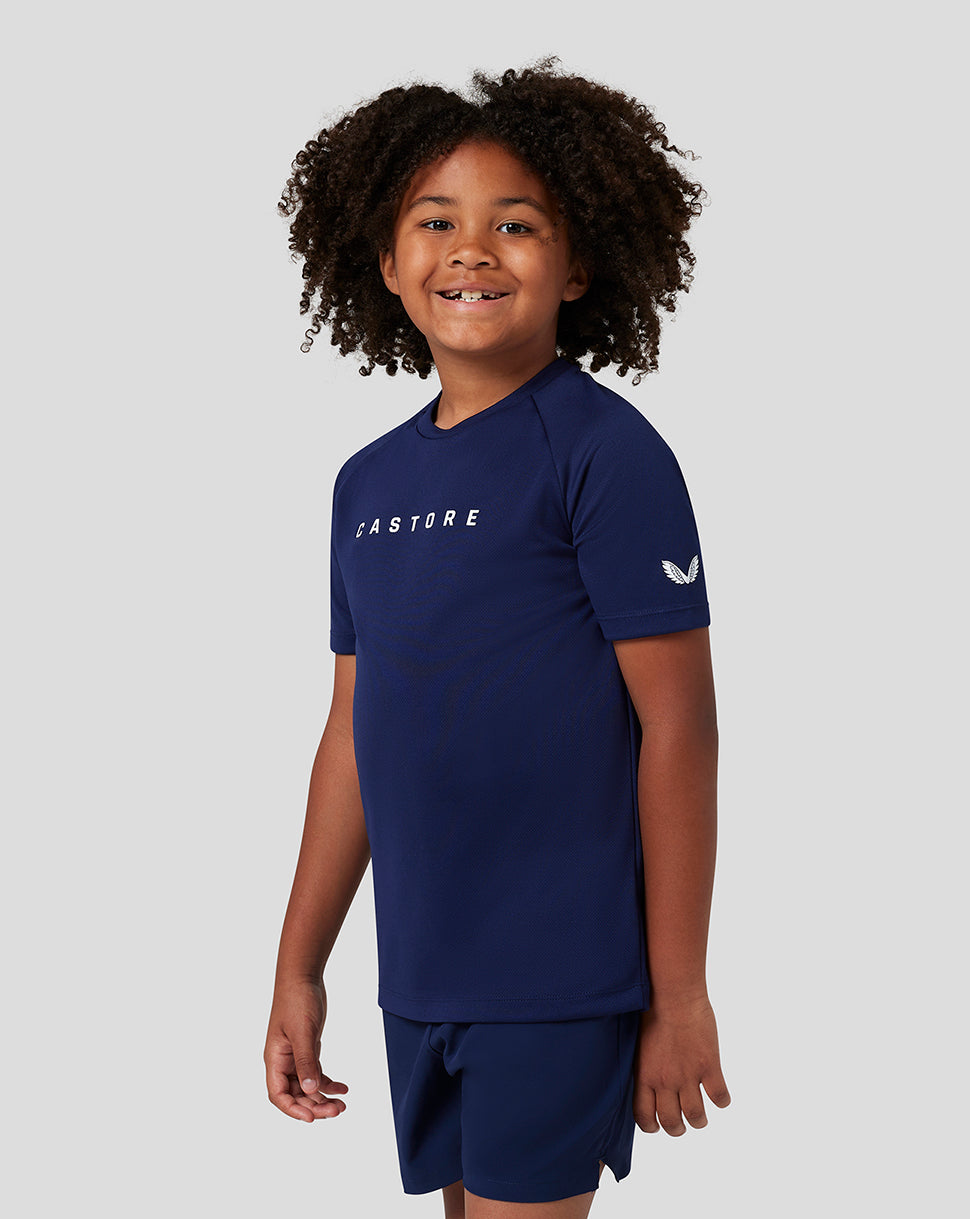 Young boy wearing navy Castore short sleeve raglan T shirt with white branding on chest and sleeve
