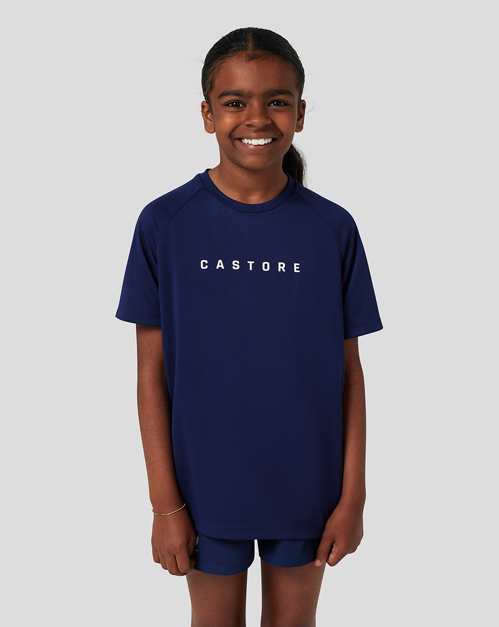 Smiling child in navy Castore short sleeve tee with bold CASTORE logo on chest