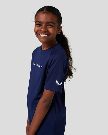 Young girl wearing navy junior Short Sleeve Raglan Tee with Castore branding on chest and sleeve