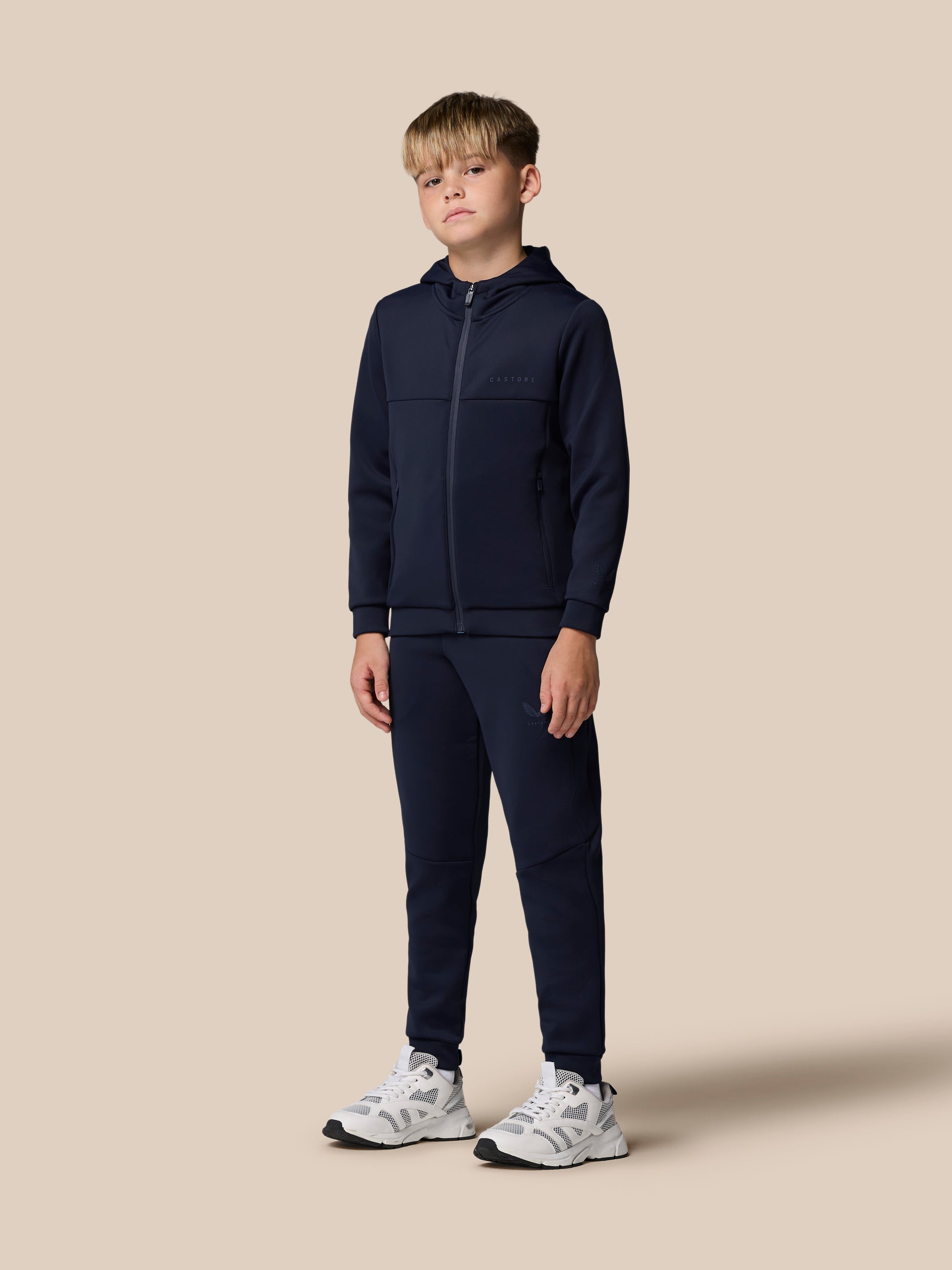 Navy Junior Flex Scuba Trousers on a child model with zip pockets and Castore logo on the leg