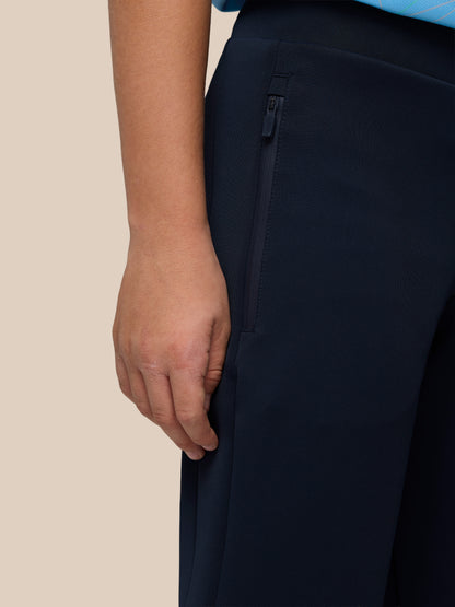 Close-up of navy Junior’s Flex Scuba Trousers showing a zippered side pocket and textured fabric.